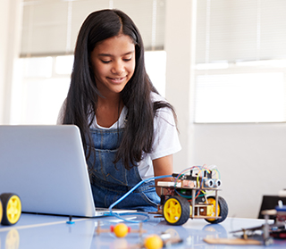 Female student building a robot using online lessons